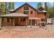 Log cabin features a porch with wood storage at 8905 Carol Ln, Conifer, CO 80433
