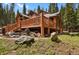 Log cabin features a deck with stone landscaping at 8905 Carol Ln, Conifer, CO 80433