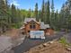 Beautiful cabin-style home featuring a stone chimney and rustic wood siding at 8905 Carol Ln, Conifer, CO 80433