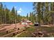 Wooded property featuring log cabin home with fire pit and parking area at 8905 Carol Ln, Conifer, CO 80433