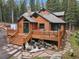Log cabin showcasing a welcoming porch with stone pathway and lush green surroundings at 8905 Carol Ln, Conifer, CO 80433