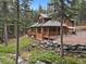 Beautifully crafted log home with a covered porch nestled beside a stream at 8905 Carol Ln, Conifer, CO 80433