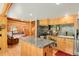 Open kitchen featuring a granite island, wooden cabinets, and seamless flow to living area at 8905 Carol Ln, Conifer, CO 80433