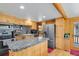 Well-equipped kitchen with granite countertops, stainless steel appliances, and wooden cabinets at 8905 Carol Ln, Conifer, CO 80433