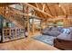 Open-concept living area with wood accents, staircase, and comfortable seating arrangement at 8905 Carol Ln, Conifer, CO 80433