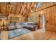 Cozy living room with wooden walls, vaulted ceiling, and comfortable sectional sofa at 8905 Carol Ln, Conifer, CO 80433