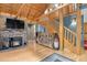 Living room features a stone fireplace, wooden accents, and staircase to the upper level at 8905 Carol Ln, Conifer, CO 80433