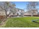 Large, grassy backyard with patio and a two-story home in the background at 14245 Corrine Ct, Broomfield, CO 80023