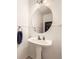 Small bathroom featuring a pedestal sink, round mirror and tiled flooring at 14245 Corrine Ct, Broomfield, CO 80023