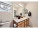 Well-lit bathroom with a single sink vanity, a toilet, and a large mirror at 14245 Corrine Ct, Broomfield, CO 80023