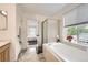 Bright bathroom features a soaking tub, a separate shower, and a window with natural light at 14245 Corrine Ct, Broomfield, CO 80023