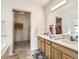 Bathroom featuring double sinks, a large mirror, and access to a walk-in closet at 14245 Corrine Ct, Broomfield, CO 80023