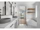 Serene bathroom featuring a sleek soaking tub, a double vanity, and elegant fixtures at 2665 Juilliard St, Boulder, CO 80305