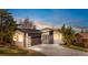 Modern exterior of a well-lit home featuring a contemporary door, two car garage and inviting landscaping at 2665 Juilliard St, Boulder, CO 80305