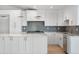 Modern kitchen with white cabinets, marble countertops, and stainless steel appliances at 2665 Juilliard St, Boulder, CO 80305