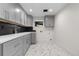 Laundry room with new gray cabinets, white countertops, black backsplash, and marbled flooring at 2665 Juilliard St, Boulder, CO 80305