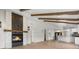 Open-concept living space with vaulted ceilings, exposed beams, fireplace, and a view into the updated kitchen at 2665 Juilliard St, Boulder, CO 80305