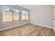 Bedroom featuring hardwood-style floors, base molding, neutral paint and window with woven blinds at 868 S Reed Ct # H, Lakewood, CO 80226
