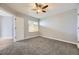 Bedroom featuring neutral carpet, ceiling fan, window, and access to nearby closet at 868 S Reed Ct # H, Lakewood, CO 80226