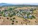 Expansive aerial view of a quiet neighborhood nestled in a landscape with rolling hills and mountain views at 10520 W Vassar Dr, Lakewood, CO 80227