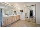 The primary bathroom features a double sink vanity, large mirror, and mirrored closet doors at 10520 W Vassar Dr, Lakewood, CO 80227