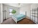 This bedroom has a white bed with turquoise blanket, and a large window providing natural light at 10520 W Vassar Dr, Lakewood, CO 80227