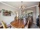 Dining room boasts a wooden table, stylish chairs, chandelier, and a view through the archway at 10520 W Vassar Dr, Lakewood, CO 80227