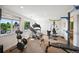 Bright home gym featuring a variety of exercise equipment and large windows at 10520 W Vassar Dr, Lakewood, CO 80227
