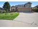 Charming two-story brick and siding home with a manicured lawn, mature trees, and a spacious driveway at 10520 W Vassar Dr, Lakewood, CO 80227