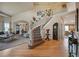 Grand foyer featuring a curved staircase, hardwood floors, and a chandelier, creating an inviting entrance at 10520 W Vassar Dr, Lakewood, CO 80227