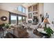 Bright living room with high ceilings, large windows showcasing scenic views, and a cozy fireplace at 10520 W Vassar Dr, Lakewood, CO 80227