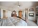 Spacious primary bedroom features a fireplace, ceiling fan, and large bed at 10520 W Vassar Dr, Lakewood, CO 80227
