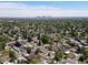 An aerial view shows the city skyline and neighborhood with tree-lined streets and well-maintained homes at 4740 W Wyoming Pl, Denver, CO 80219