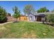 Lush backyard featuring a well-manicured lawn, privacy fence, and an outdoor entertaining area at 4740 W Wyoming Pl, Denver, CO 80219