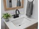 Bright bathroom with a white countertop, modern black faucet, and a stylish wood-trimmed mirror at 4740 W Wyoming Pl, Denver, CO 80219