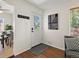 Inviting entryway with hardwood floors, modern art, and a bright white door with window panes at 4740 W Wyoming Pl, Denver, CO 80219