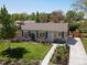 Charming single-story home featuring a well-manicured front yard with mature landscaping, new sidewalk, and a cozy front porch at 4740 W Wyoming Pl, Denver, CO 80219