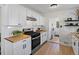 Bright kitchen featuring white cabinets, butcher block countertops, stainless steel appliances, and wood-look flooring at 4740 W Wyoming Pl, Denver, CO 80219