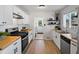 Well-lit kitchen featuring modern appliances, white cabinets, butcher block counters, and backyard access at 4740 W Wyoming Pl, Denver, CO 80219