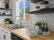 Close-up of kitchen sink and butcher block countertops featuring stainless appliances and updated fixtures at 4740 W Wyoming Pl, Denver, CO 80219