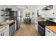 Spacious eat-in kitchen with stainless steel appliances, open shelving, and a view to the dining area at 4740 W Wyoming Pl, Denver, CO 80219