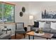 Comfortable seating area with a gray sofa, decorative art, and natural light through a window at 4740 W Wyoming Pl, Denver, CO 80219