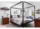 Comfortable bedroom with a four-poster bed, warm tones, and natural light from nearby windows at 501 S Race St, Denver, CO 80209