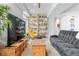 Open living room with a TV, bookshelf, stylish chairs, and comfortable seating arrangement at 501 S Race St, Denver, CO 80209