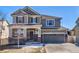 Inviting two-story home featuring a brick-accented front porch and a well-maintained lawn at 17806 Coral Burst St, Parker, CO 80134