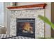 Close-up of a modern fireplace with a stone surround and a wood mantel at 17806 Coral Burst St, Parker, CO 80134