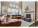 Cozy living room with a stone fireplace, plush ottomans, and a comfortable sectional couch at 17806 Coral Burst St, Parker, CO 80134
