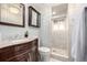 Nicely renovated bathroom with granite-topped vanity, medicine cabinet, and tiled shower with window at 7912 Fenton St, Arvada, CO 80003