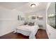 Cozy bedroom with white walls, wood floors, comfy queen-sized bed, and decoratively framed art at 7912 Fenton St, Arvada, CO 80003