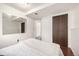 A neutral bedroom featuring hardwood floors, a mirrored wall, and a closet with paneled doors at 7912 Fenton St, Arvada, CO 80003